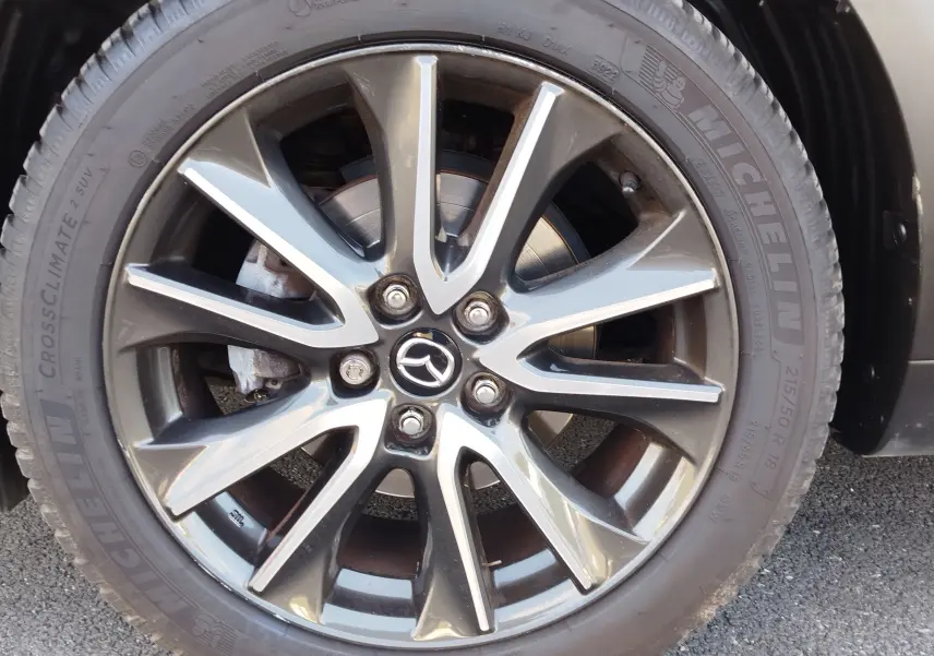 Gros plan sur la jante alliage grise et noire du Mazda CX-3 2016 avec pneu Michelin CrossClimate.