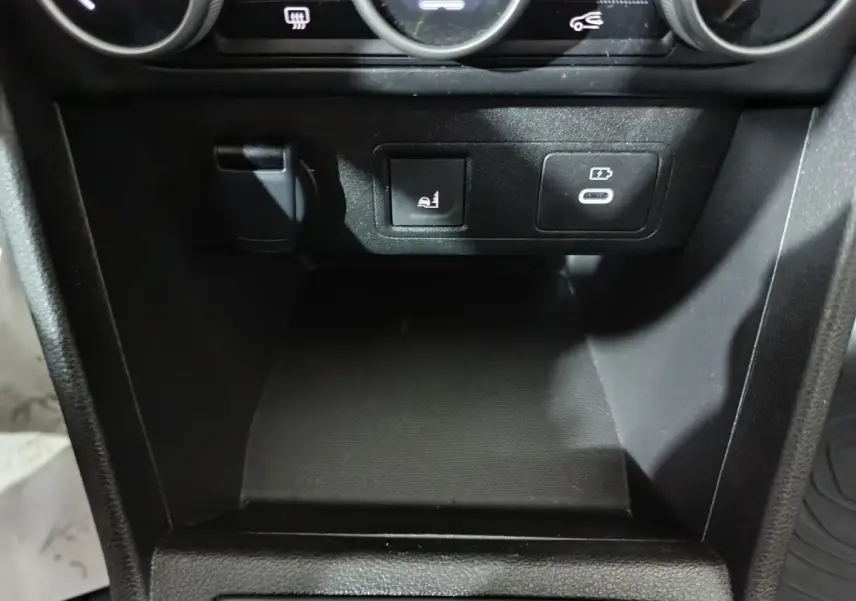 Détail de la console centrale noire de la Dacia Sandero Extreme+ 2024 avec prise USB-C et bouton de siège chauffant.