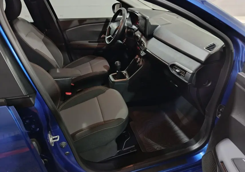 Vue intérieure côté conducteur de la Dacia Sandero Extreme+ TCe 110 2024 bleu, avec volant multifonctions et sièges bi-matière.