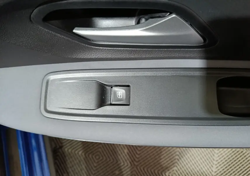 Gros plan sur la commande de lève-vitre côté conducteur de la Dacia Sandero Extreme+ bleu 2024.