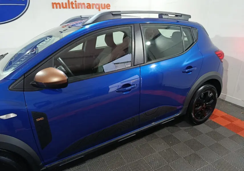 Vue latérale droite d'une Dacia Sandero Extreme+ bleu avec rétroviseurs bronze et jantes noires.