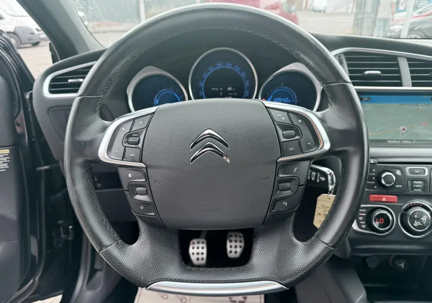 Vue intérieure centrée sur le volant noir de la Citroën DS4 2012 avec tableau de bord et écran GPS visible.