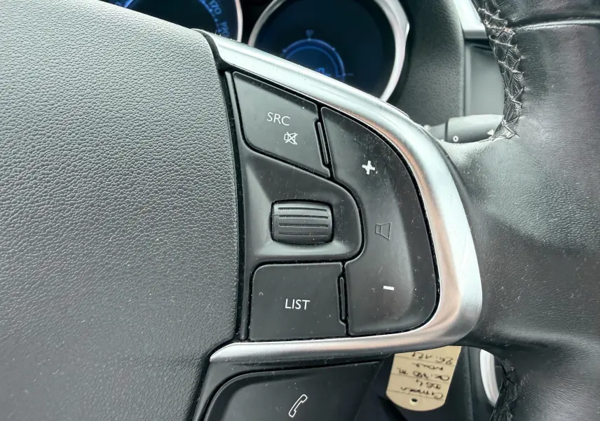 Gros plan sur les commandes de volume et téléphone au volant en cuir noir d'une Citroën DS4 2012.