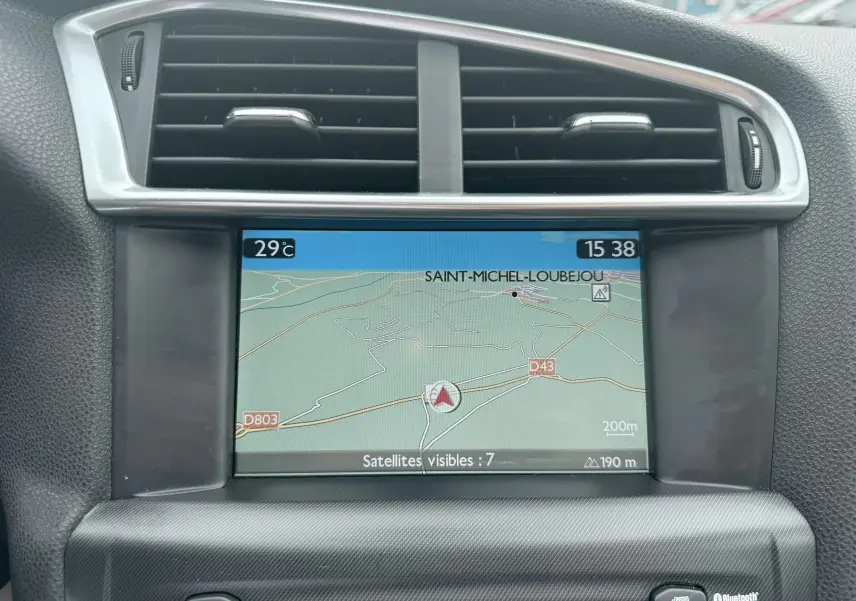 Écran GPS central avec carte routière affichée, entouré d'aérations noires et cadre argenté dans un Citroën DS4 noir.