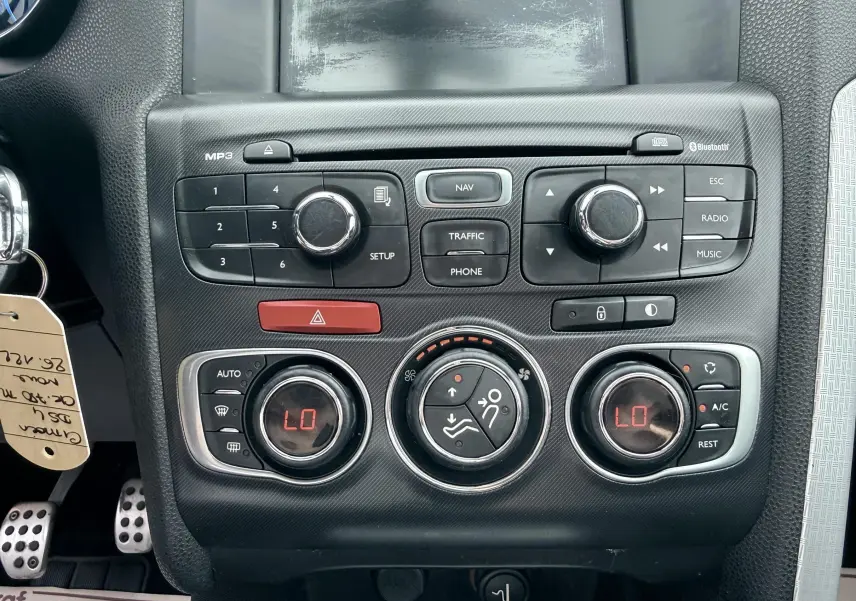 Vue rapprochée de la console centrale noire du Citroën DS4 2012, montrant les commandes de climatisation et multimédia.