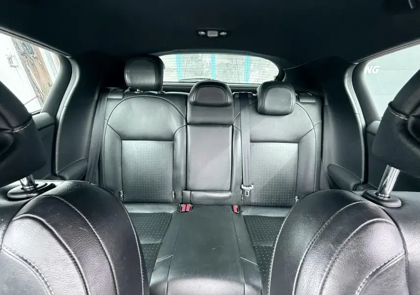 Vue intérieure arrière centrée sur les sièges en cuir noir de la Citroën DS4, avec appuie-têtes et ceinture de sécurité visible.