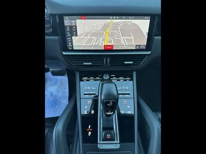 Vue plongeante sur la console centrale du Porsche Cayenne Coupe 3.0 V6 340CV 2020, avec écran GPS et levier de vitesses noir.