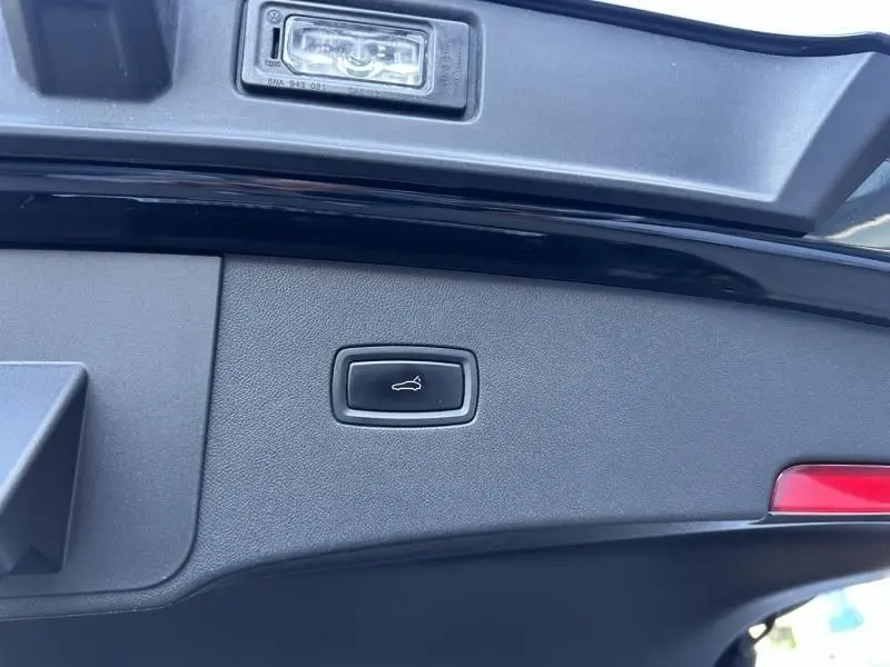 Bouton de fermeture électrique du hayon sur le coffre arrière d'un Porsche Cayenne Coupe noir métal 2020.