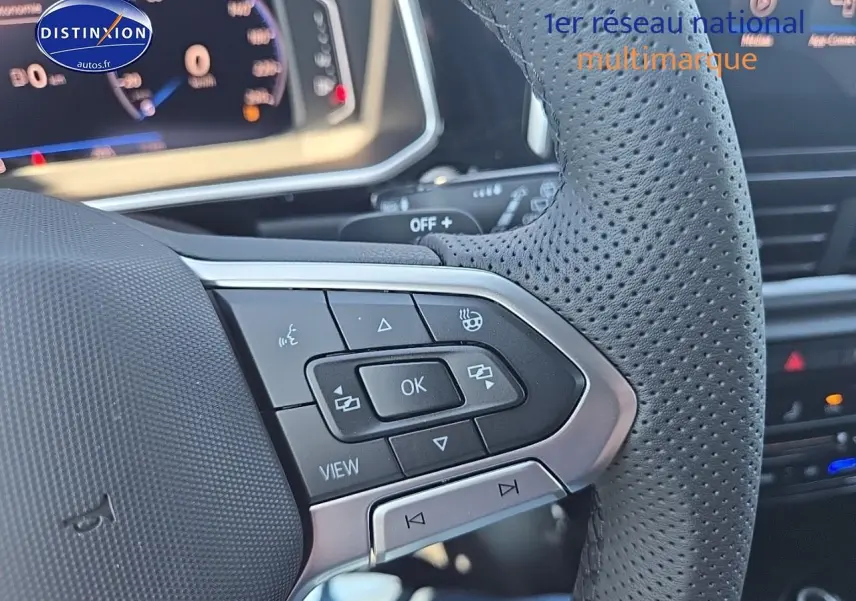 Gros plan sur le volant cuir perforé et ses commandes multifonctions du Volkswagen T-Roc noir perle 2025.