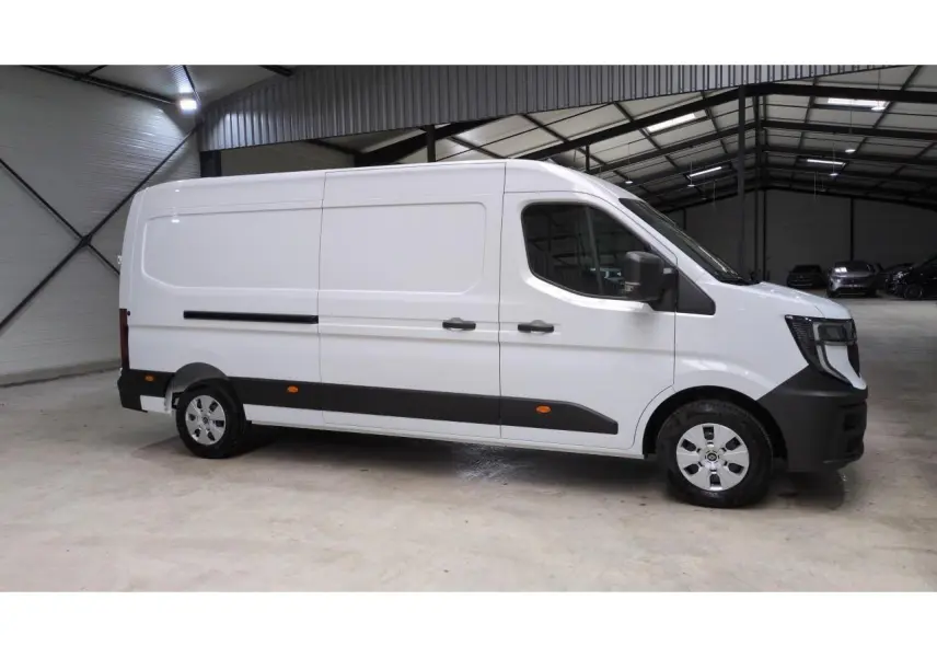 Vue latérale droite du Renault Master blanc 2025 avec bandes noires et jantes argentées dans un entrepôt.