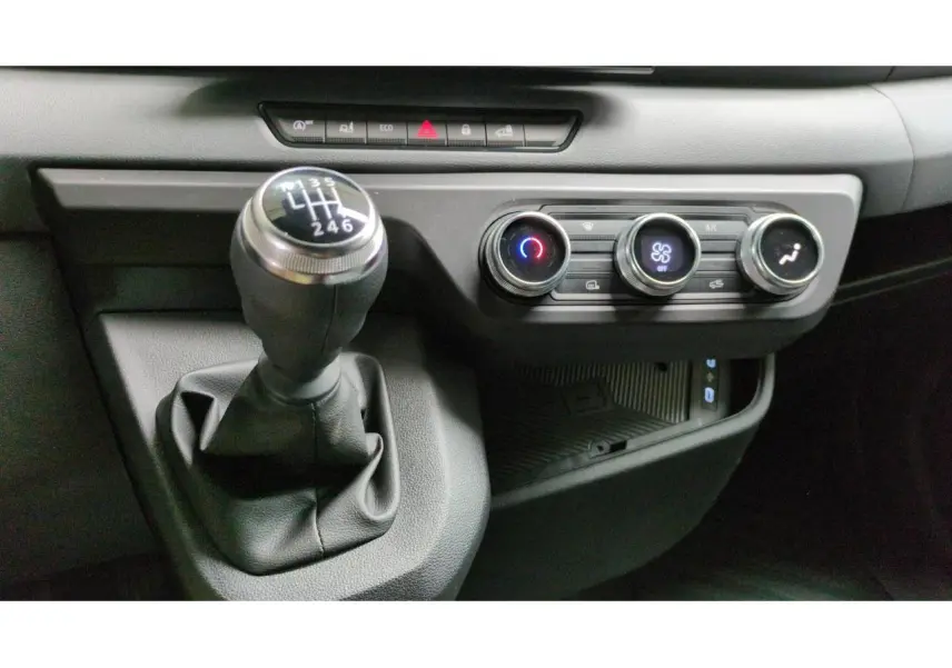 Gros plan sur le levier de vitesses manuel et les commandes de climatisation du Renault Master blanc 2025.