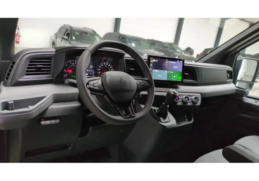 Vue intérieure côté conducteur du Renault Master 2025 avec tableau de bord digital et écran tactile central.