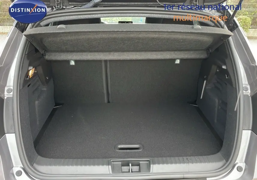 Coffre ouvert d'un Renault Captur E-Tech gris Cassiopée métal avec toit noir, vue arrière montrant l'espace de chargement.