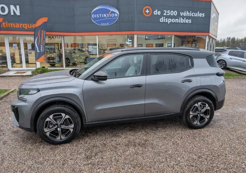 Vue de profil côté gauche d'un Citroën C3 Aircross 2025 gris métallisé avec toit noir Perla Nera et jantes alliage.