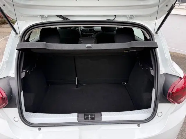 Coffre ouvert vu de l'arrière d'une Dacia Sandero blanc glacier 2023, montrant l'espace de chargement vide.