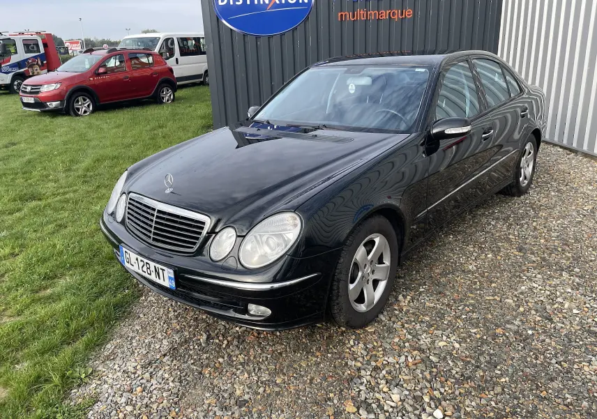Mercedes Classe E 320 CDI noire vue en 3/4 avant droit, avec calandre chromée et jantes alliage d'origine.