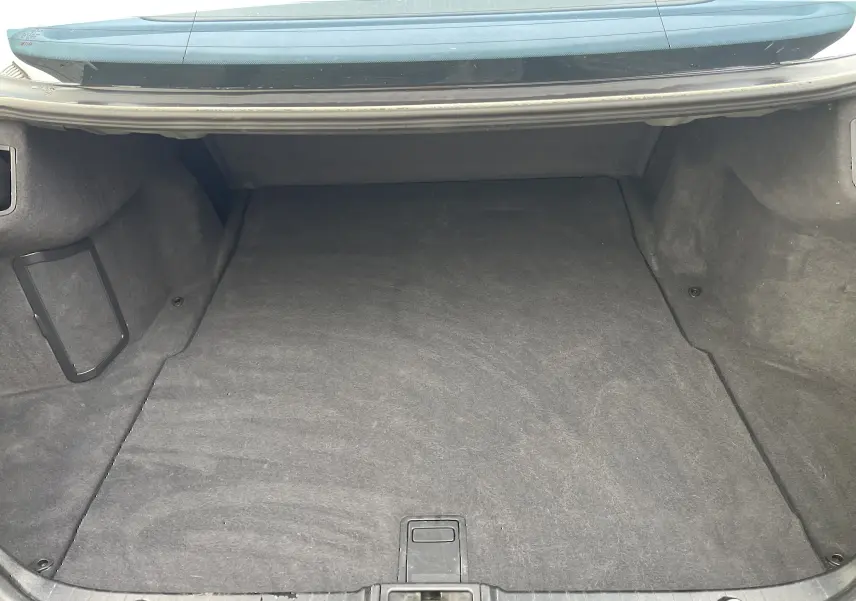 Coffre ouvert vu de face d'une Mercedes Classe E 320 CDI Elegance noire de 2003, espace de chargement vide et propre.