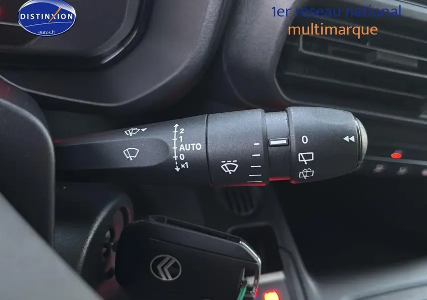 Gros plan sur la commande d’essuie-glace à gauche du volant dans l’habitacle du Citroën Berlingo Fourgon blanc 2025.