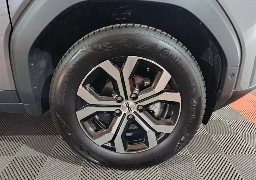 Gros plan sur la roue avant droite du Dacia Bigster gris foncé, mettant en valeur la jante alliage noire et argentée.