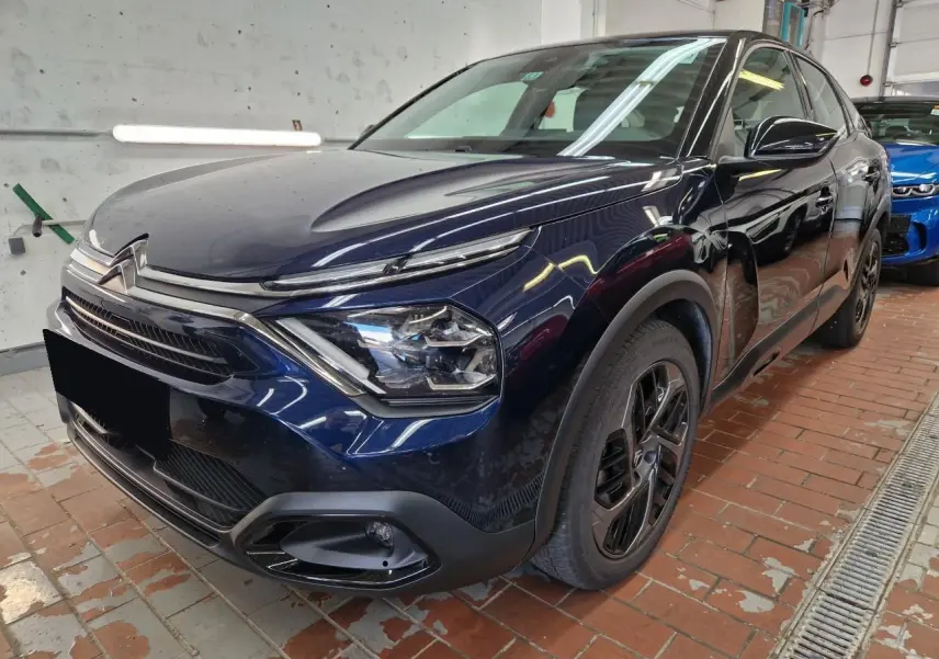 Citroën C4 2024 bleu Eclipse vue 3/4 avant droit avec toit noir Perla et jantes alliage noires.