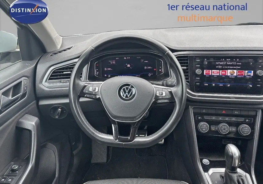 Vue intérieure du tableau de bord et volant noir du Volkswagen T-Roc 2021 avec écran tactile et commandes au volant.