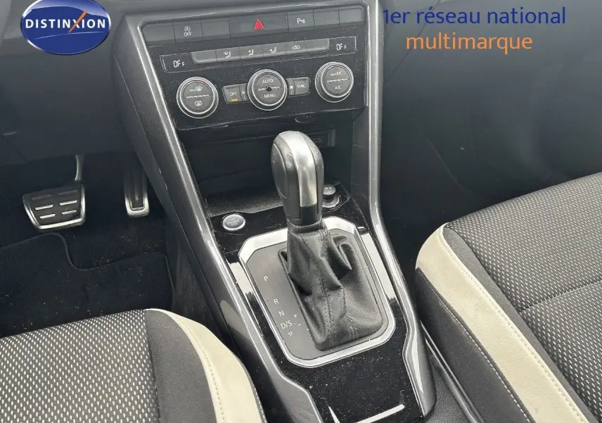 Vue rapprochée de la console centrale du Volkswagen T-Roc blanc argenté, mettant en valeur le levier de vitesse automatique.