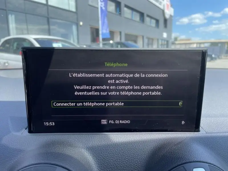 Écran central du tableau de bord de l'Audi Q2 noir métal 2022 affichant la connexion Bluetooth pour téléphone portable.
