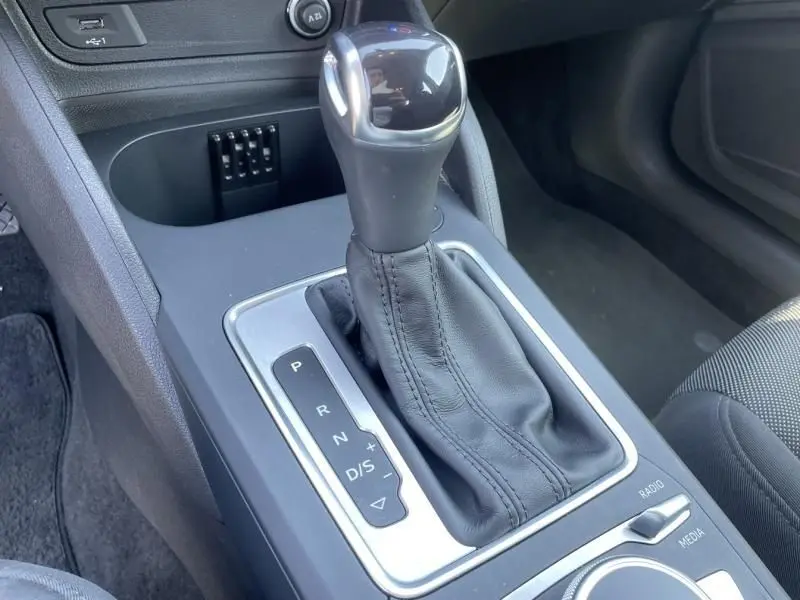 Le levier de vitesse automatique en cuir noir de l'Audi Q2 TFSI 150CV Advanced S-Tronic, vue rapprochée côté console centrale.