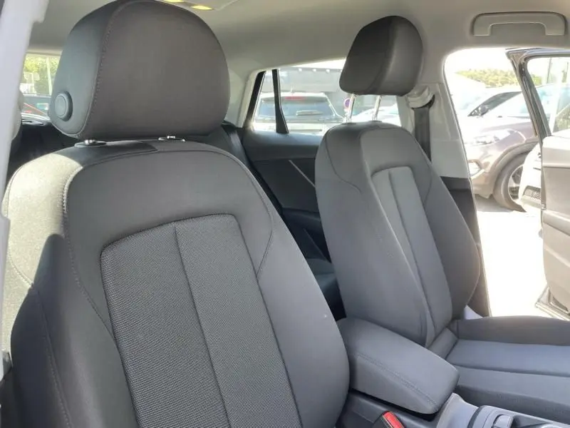 Vue intérieure des sièges avant en tissu gris foncé de l'Audi Q2 noir métal, version TFSI 150CV Advanced S-Tronic 2022.