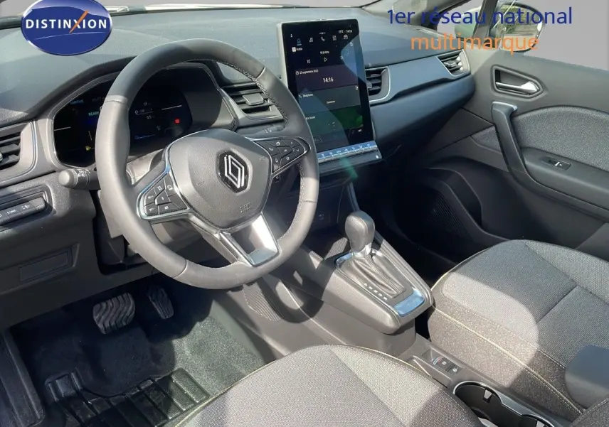 Intérieur du Renault Captur E-Tech hybride 2025, vue côté conducteur sur volant, écran tactile et console centrale grise.