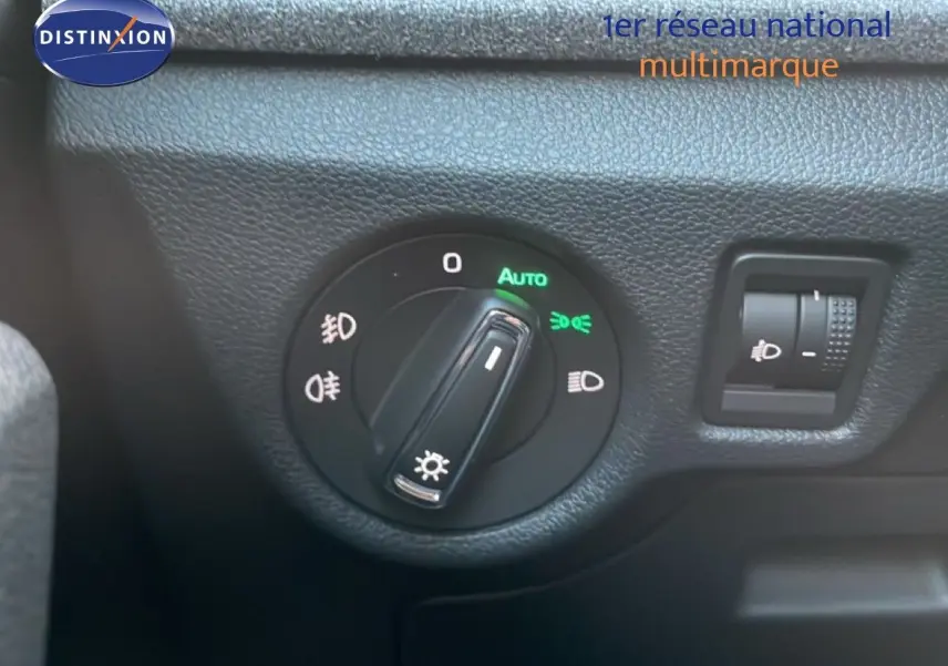 Gros plan sur le sélecteur de phares avec fonction automatique du Skoda Kamiq gris argent, intérieur côté gauche.