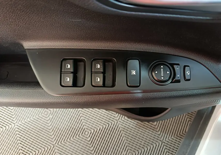 Vue rapprochée des commandes de porte côté gauche du KIA Stonic gris clair, avec réglage des rétroviseurs et boutons de verrouillage.