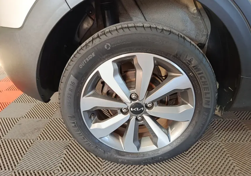 Gros plan sur la roue avant droite d’un KIA Stonic gris clair, avec jante alliage et pneu Michelin visible.