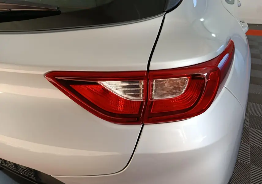Gros plan sur le feu arrière droit du KIA STONIC gris clair, mettant en valeur la finition lisse de la carrosserie.