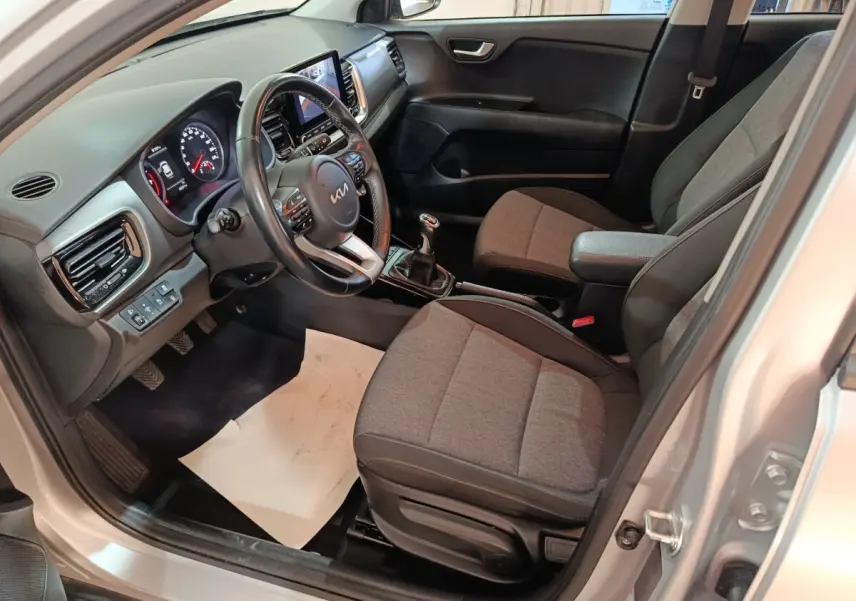 Vue intérieure côté conducteur du Kia Stonic gris clair 2022, avec tableau de bord numérique et volant multifonctions.
