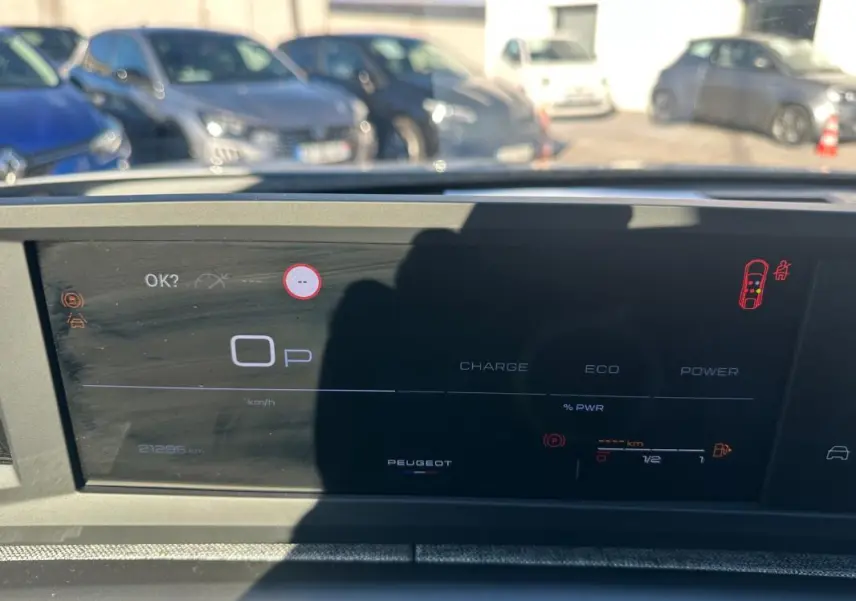 Vue rapprochée du cockpit numérique du Peugeot 3008 blanc, affichant les indicateurs de charge et de puissance.
