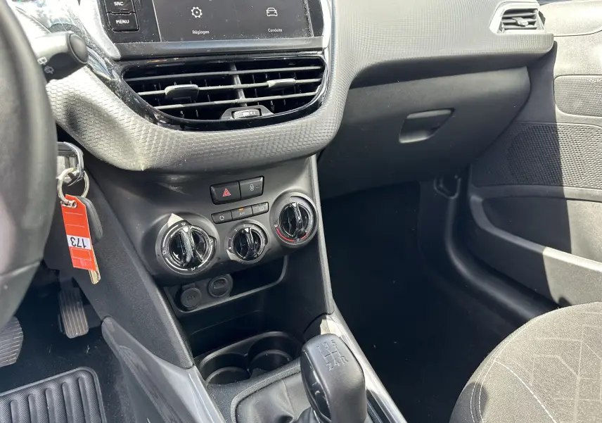 Vue intérieure côté conducteur du tableau de bord et levier de vitesse manuel d'une Peugeot 2008 gris 2019.