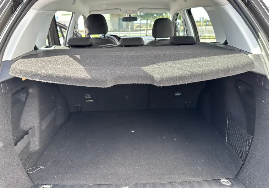 Vue arrière du coffre spacieux et vide d'un Peugeot 2008 gris 2019, avec cache-bagages en tissu déployé.