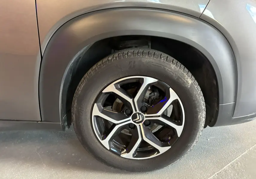 Gros plan sur la roue avant droite du Citroën C3 Aircross gris platinium avec jante alu bi-ton et passage de roue noir.