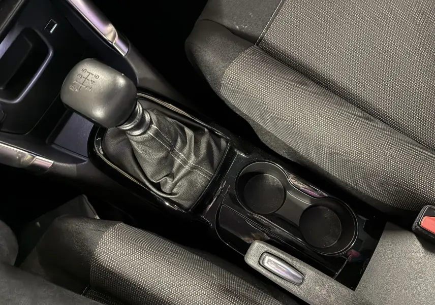 Gros plan sur la console centrale avec levier de vitesse manuel et sièges tissu gris noir de la Citroën C3 Aircross 2023.