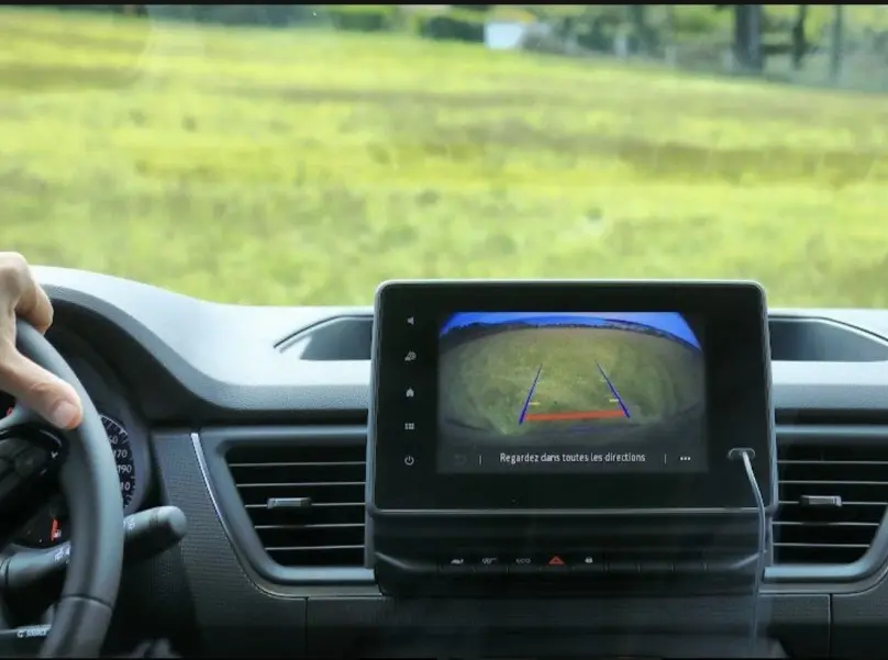 Vue intérieure du tableau de bord du Renault Trafic Fourgon gris 2025, écran caméra de recul en fonctionnement.