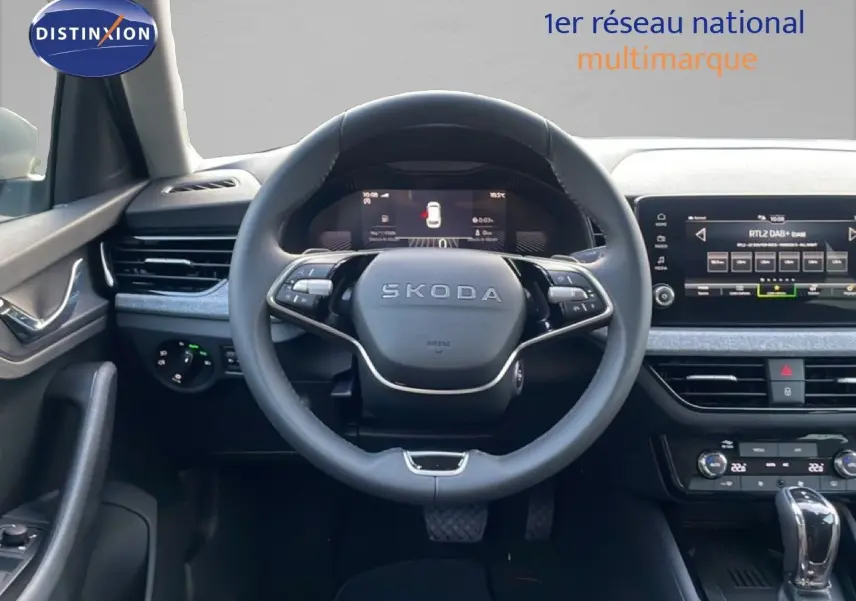 Vue intérieure centrée sur le volant SKODA du KAMIQ avec tableau de bord numérique et écran tactile gris argent métal.