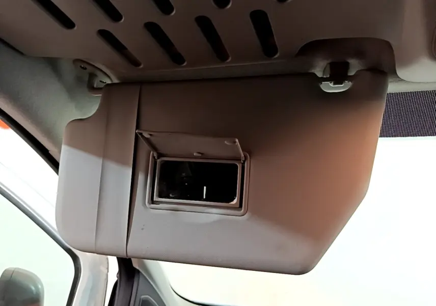Détail du pare-soleil côté conducteur avec miroir intégré dans l'habitacle du Ford Transit Fourgon blanc.