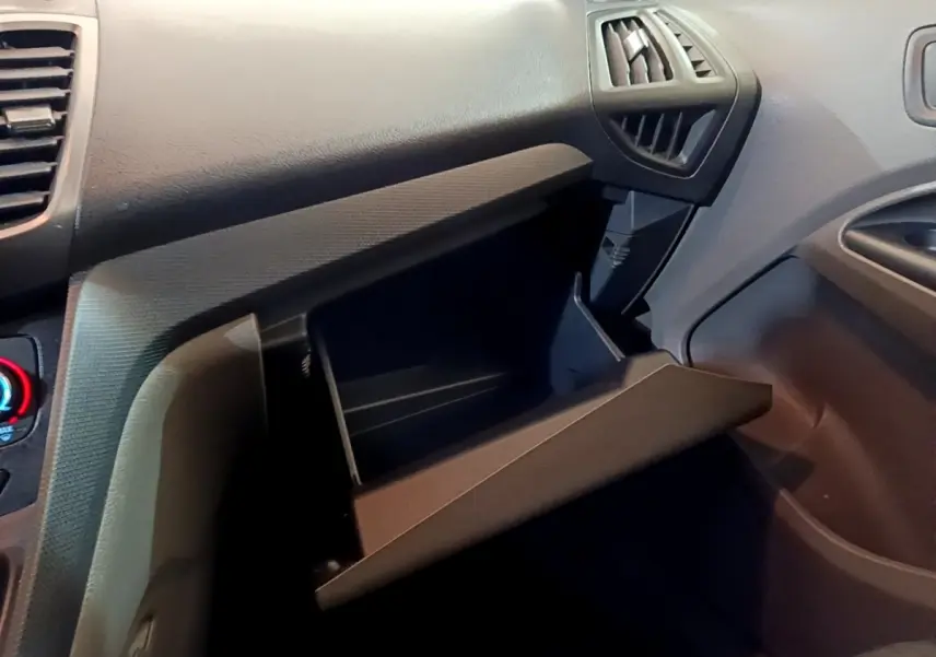 Vue intérieure du tableau de bord côté passager du Ford Transit Fourgon 2022 avec boîte à gants ouverte en plastique noir.