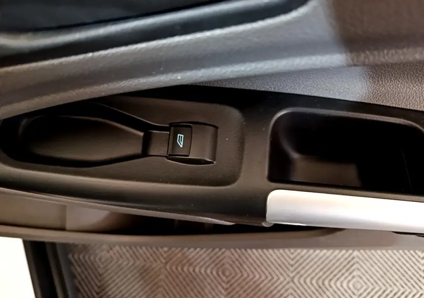 Gros plan sur le bouton de commande de la vitre électrique côté conducteur du Ford Transit Fourgon blanc.