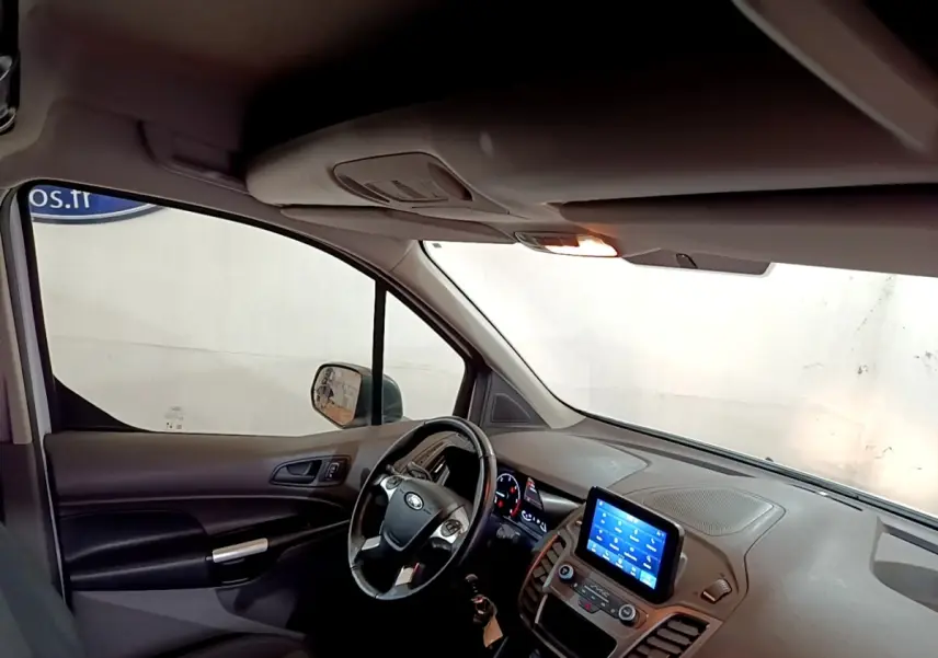 Vue intérieure côté conducteur du Ford Transit Fourgon 2022 avec tableau de bord et écran tactile central allumé.