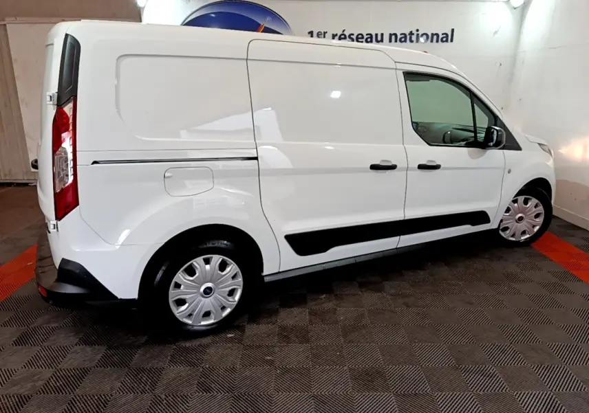 Vue de profil côté droit d'un fourgon Ford Transit blanc, avec jantes argentées et poignées noires.