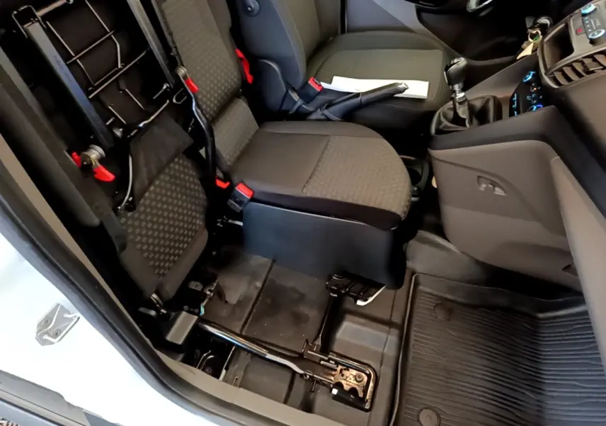 Vue intérieure côté conducteur du Ford Transit Fourgon 2022, sièges gris foncé et levier de vitesse manuel visibles.