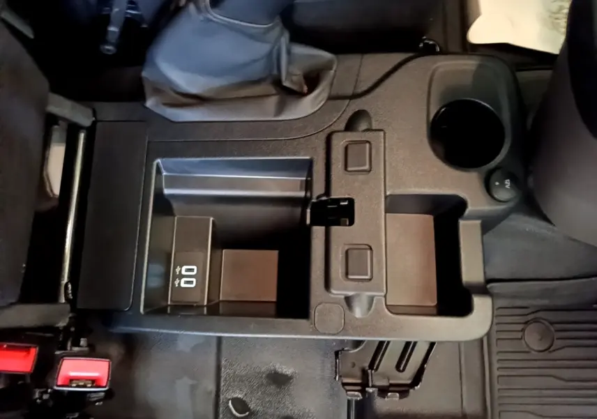 Vue plongeante sur la console centrale noire du Ford Transit Fourgon 2022, avec prise USB et porte-gobelet.