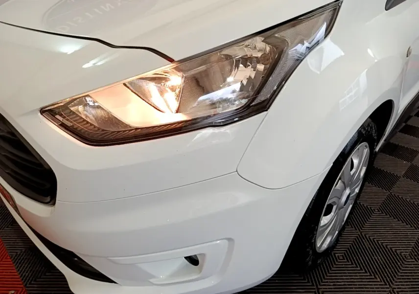 Gros plan sur l'avant droit blanc du Ford Transit Fourgon 2022 avec phare allumé et jante visible.